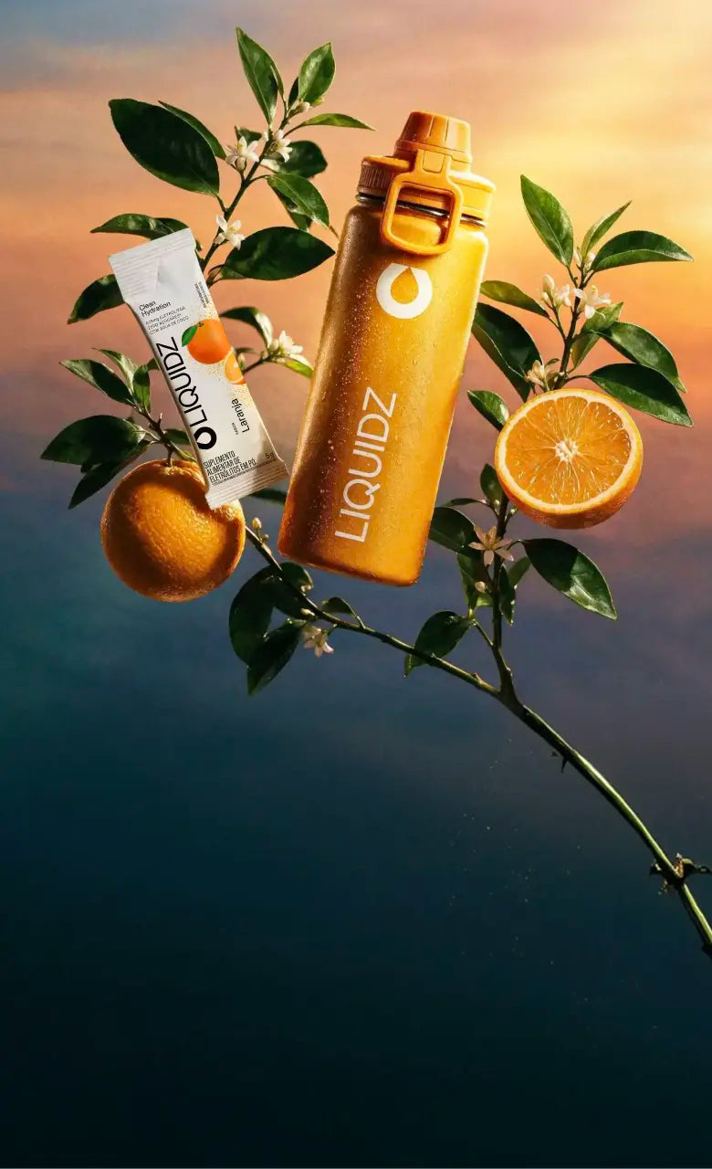 Garrafa e sachê de LIQUIDZ Laranja entre laranjas e flores de laranjeira
